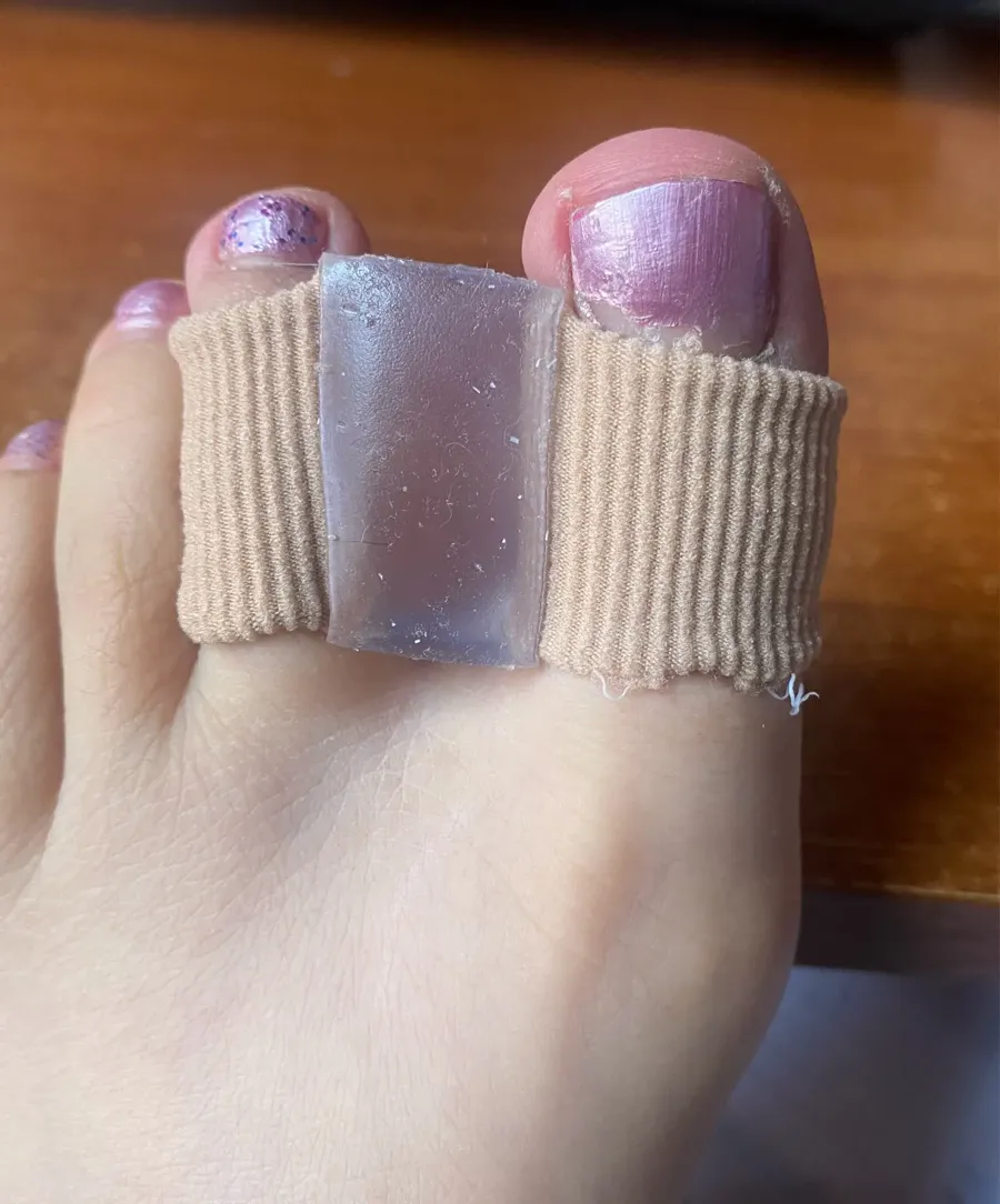 Buyer photo of a beige toe separator tube worn on a toe